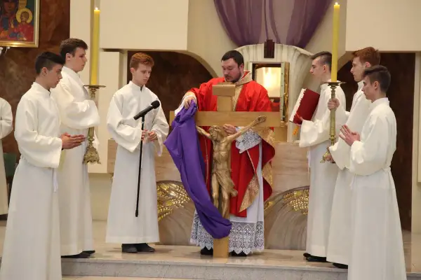 Podczas wielki piątek msza, kapłan prezentuje krzyż z figurą Chrystusa. Ceremonii towarzyszą ministranci w białych szatach.