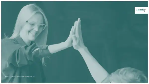 Uśmiechnięta kobieta w okularach daje "piątkę". Czy to przejaw ekstrawersji? #HRTech #Psychometria #Rekrutacja