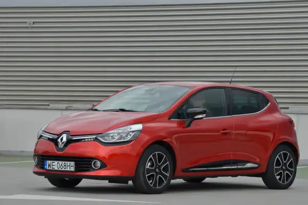 Czerwony Renault Clio 4 z nowoczesnymi światłami, które podkreślają jego dynamiczny wygląd. Żarówki przód świecą jasno, gotowe na każdą podróż.