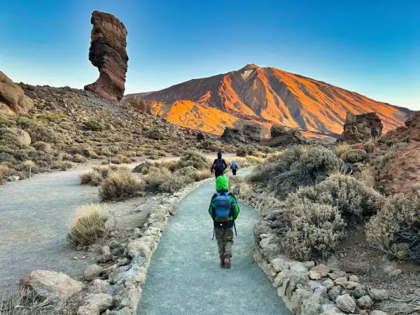 Rodzina wyrusza na wejście na Teide. W tle wulkan w złotym świetle, po lewej charakterystyczna skała.