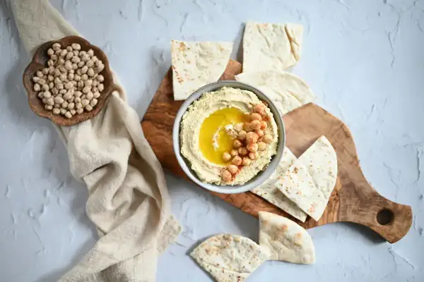 Krämig hummus med kikärtor och olivolja, serverad med pitabröd. Ett perfekt hummus recept för alla tillfällen.