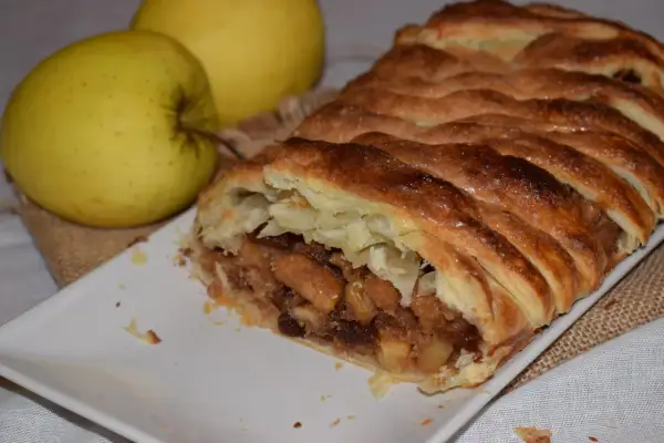 Delicioso hojaldre de manzana y canela, con trozos de manzana y pasas, horneado hasta dorar.