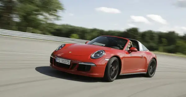 Czerwony Porsche 911 GTS Targa pędzi po torze wyścigowym, kierowca cieszy się jazdą.