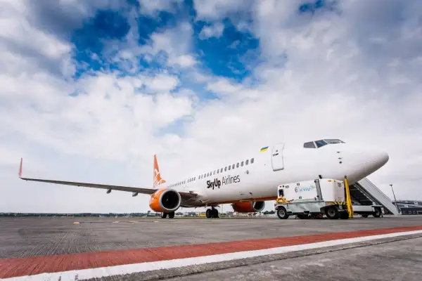 Samolot SkyUp Airlines gotowy do startu. W tle błękitne niebo z chmurami.