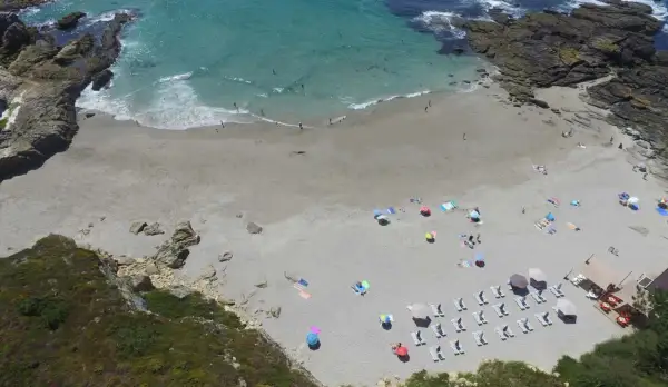 Vista aérea de la playa Paxariñas con gente disfrutando del sol y el mar.
