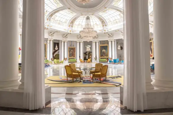 Eleganckie wnętrze hotelu Best Negresco z kryształowymi żyrandolami, marmurową posadzką i luksusowymi meblami.