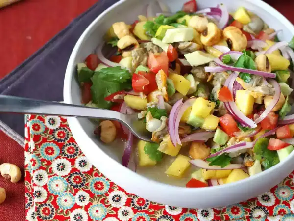 Delicioso ceviche de berberechos con mango, aguacate, tomate y cebolla morada. Una explosión de sabor fresco y vibrante.