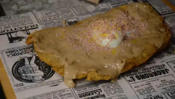 Plato de comida con huevo y salsa, ideal para comer barato en Zaragoza cerca del Pilar.