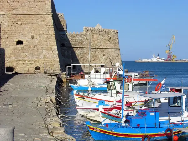 Port w Heraklionie, Kreta. Wrzesień, idealna temperatura na rejs. W tle twierdza, łodzie rybackie i dźwig portowy.