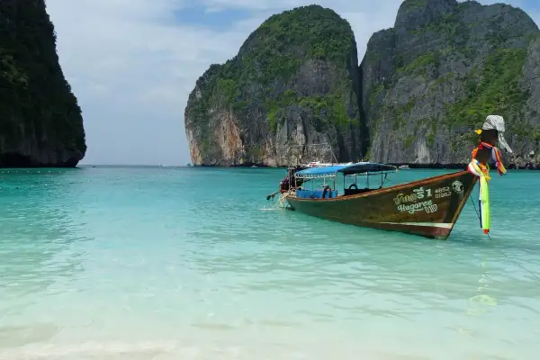 Łódź kołysze się na turkusowych wodach Maya Bay, otoczonej stromymi, porośniętymi zielenią klifami.