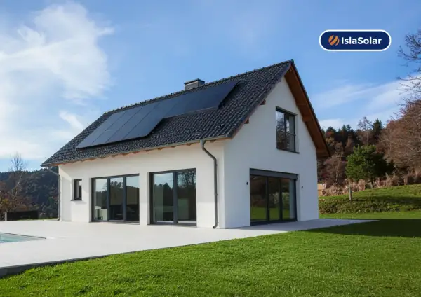 Casa moderna con placas solares en el tejado, ideal para sustituir uralita y generar energía limpia.