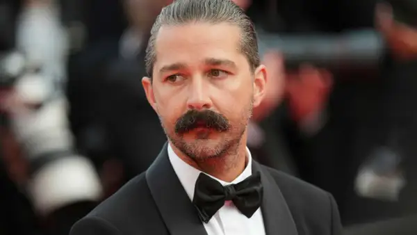 Shia LaBeouf med mustasch och fluga, redo för röda mattan.