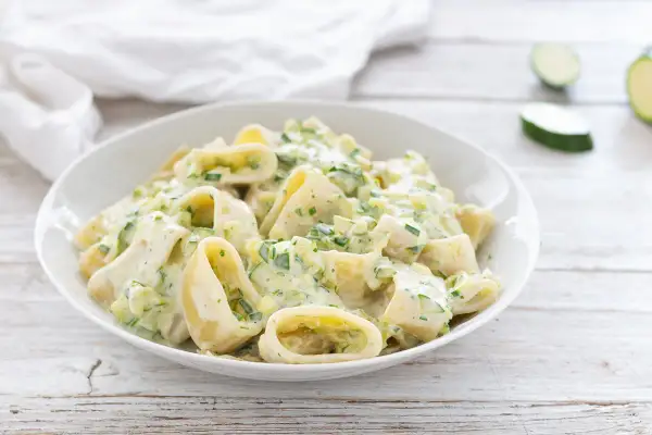Piatto di pasta robiola e zucchine, cremoso e invitante, con pezzi di zucchine fresche e erbe aromatiche.