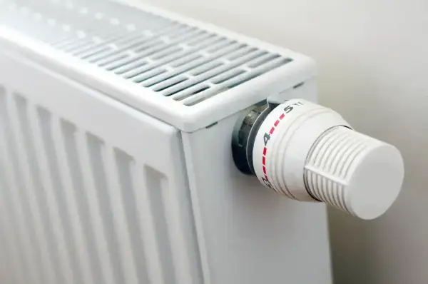 Biały grzejnik z termostatem. Gdy nie grzeje, sprawdź, jak naprawić grzejnik elektryczny, zaczynając od regulacji pokrętła.