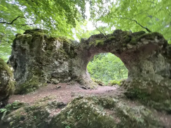 Arco natural cubierto de musgo en la sierra de Entzia, ideal para rutas de senderismo.