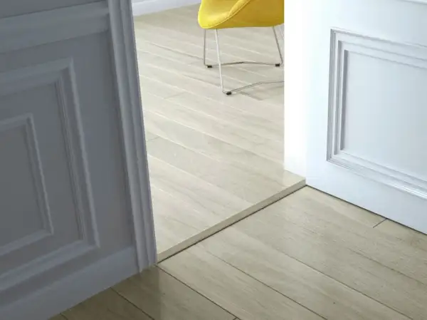 Une alternative barre de seuil discrète sépare deux pièces aux sols en parquet clair.