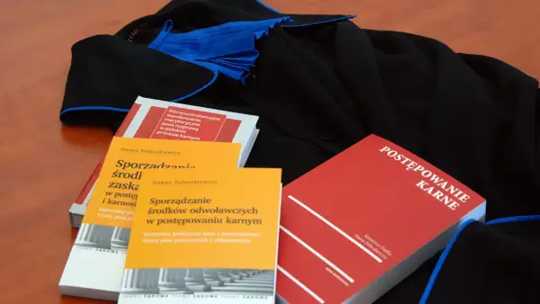 Książki prawnicze o postępowaniu karnym i sporządzaniu środków odwoławczych leżą obok tog. Czy rozprawa może się odbyć bez oskarżonego?