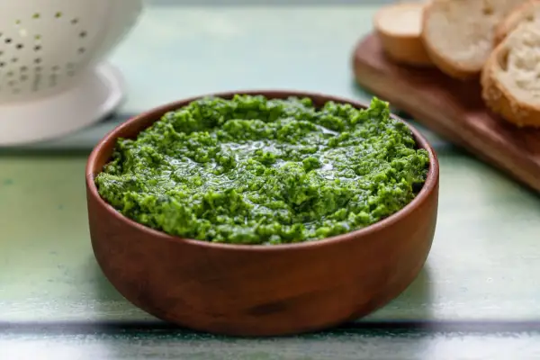 Pesto di rucola Bimby appena fatto, pronto per essere gustato con crostini di pane.