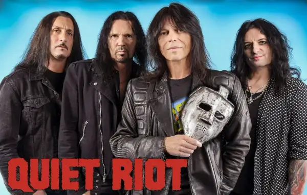 Los miembros de Quiet Riot posan con una máscara de hockey plateada.