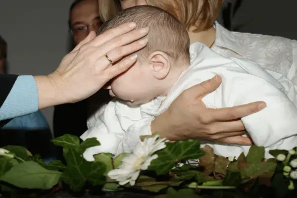Rytuał chrztu: ręka matki błogosławi dziecko. Co zrobić że świeca po chrzcie? Zachowaj ją jako pamiątkę.
