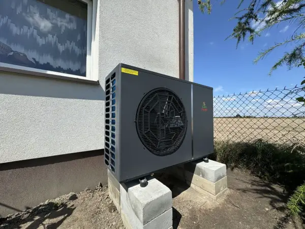 Nowoczesna pompa ciepła Geo Power zamontowana na betonowych bloczkach. Rozważasz inwestycję? Sprawdź, jaki pompa ciepła koszt.
