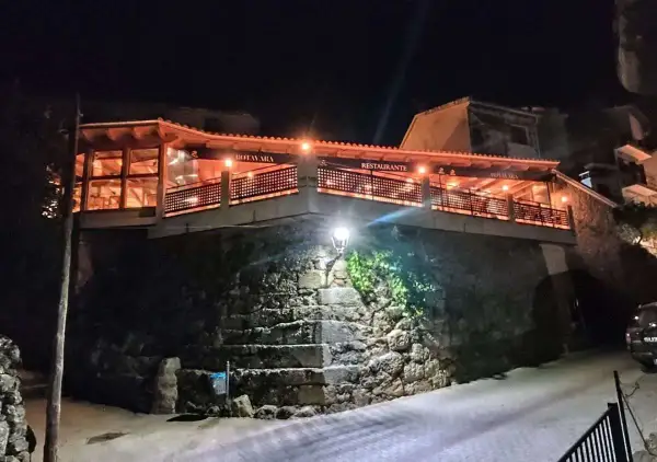Restaurante Botavara San Jose, iluminado por la noche, con escaleras de piedra y una vista acogedora.
