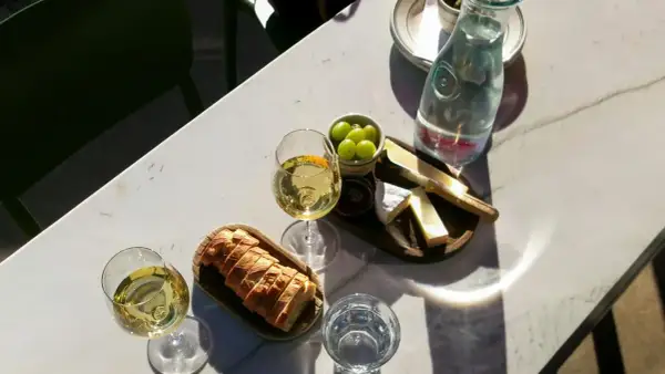 Dwa kieliszki białego wina, idealne do deski serów i pieczywa. Może to być orzeźwiające grenache wino.