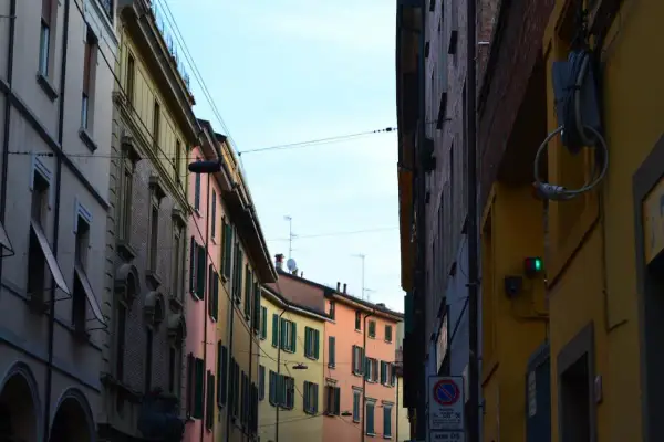 Edifici colorati di Bologna, con un semaforo verde che promette una vivace vita notturna.