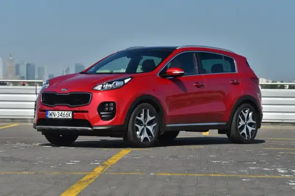 Czerwona Kia Sportage 2.0 diesel, z czarnym dachem, na parkingu. Zastanawiasz się, ile pali?