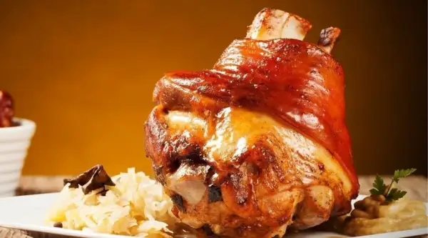 Soczysta golonka pieczona, podana z kapustą i musztardą. Idealna marynata do golonki sprawia, że mięso jest kruche i aromatyczne.