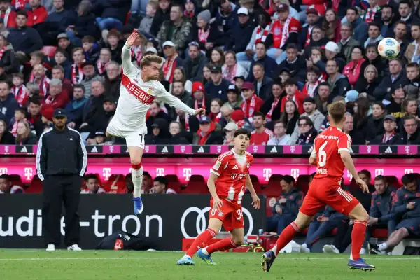 Fußballer in Aktion beim Pokalfinale Berlin. Ein Spieler in Weiß springt, während ein Spieler in Rot ihn beobachtet.