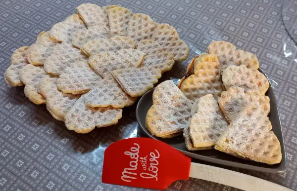 Cuore di cialde morbide spolverate di zucchero a velo, pronte per essere gustate.