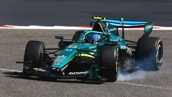 Coche Aston Martin verde en pista, humeando al girar. Un momento de pura adrenalina en el mundial F1.