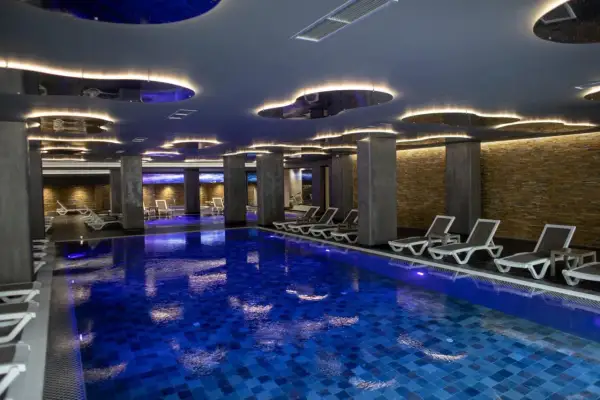 Nowoczesny basen w hotelu dla dorosłych w Polsce. Luksusowe leżaki i nastrojowe oświetlenie tworzą idealną atmosferę relaksu.