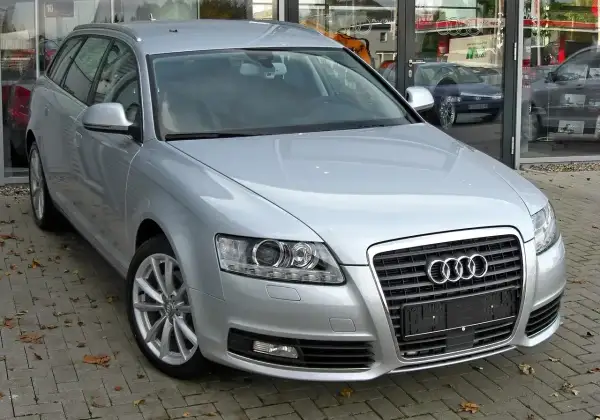 Srebrne Audi A6 C6 2.7 TDI Avant zaparkowane przed salonem.