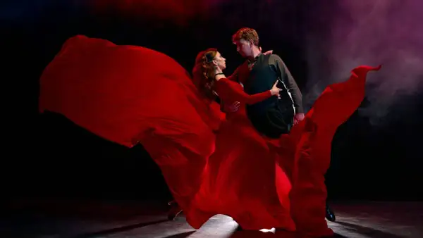 Tancerze w czerwieni, w wirze sukni, tworzą widowiskowy performance. To sztuka ruchu, emocji i pasji.
