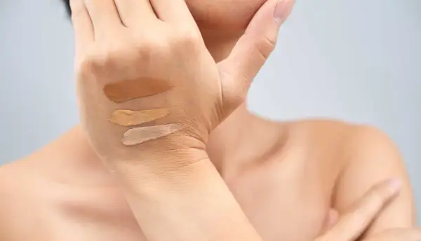 Tre campioni di fondotinta su una mano, utili per capire come scegliere il sottotono della pelle.