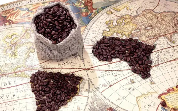 Kaffebönor i en säck och formade som ett hjärta och Afrika på en gammal världskarta. Vem uppfann kaffe? Kanske en upptäcktsresande!