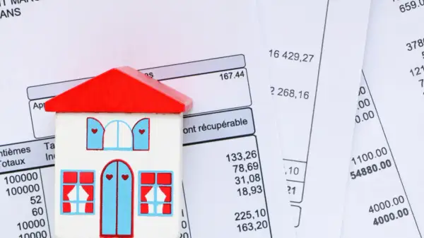 Maison en bois sur des factures. Apprenez comment calculer la taxe d'habitation.
