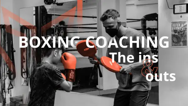 A coach demonstrates boxing techniques to a young boxer, highlighting the ins and outs of coaching boxing.