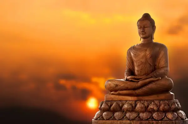 Buddha-staty i solnedgången. Lär dig fakta om buddhismen och dess symbolik.