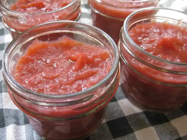 Fyra små glasburkar fyllda med hemgjord rabarbermarmelad. Perfekt för frukostmackan eller till desserten.