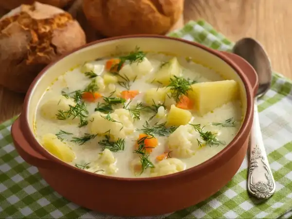 Kremowa zupa z kalafiora i ziemniaków, posypana koperkiem. Idealna na chłodne dni, jedna z tych dobrych zup domowych.