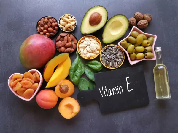 Vielfalt an vitamin e lebensmittel: Nüsse, Samen, Avocado, Mango, Spinat, Oliven, Aprikosen und Öl.