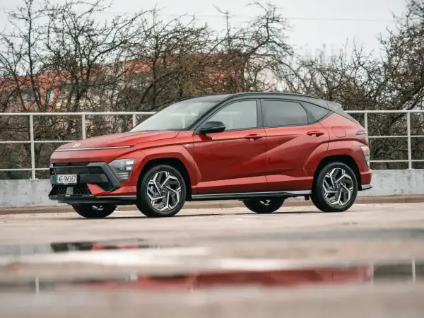 Czerwony Hyundai Kona Hybrid, idealny do miasta, z niskim spalaniem. Stylowy SUV na mokrej nawierzchni.