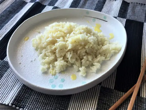 Piatto di riso in bianco, semplice e profumato, pronto per essere gustato con le bacchette.
