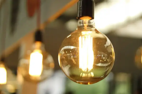 Żarówki Edisona świecą jasno, przypominając o rachunkach za prąd. Zastanawiasz się, ile kosztuje 1 kWh Enea?