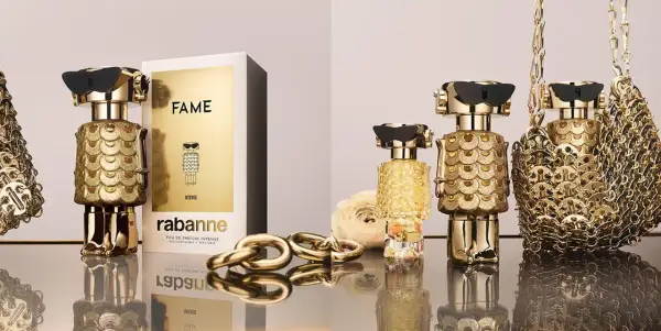Złote flakony perfum FAME od Rabanne, ozdobione łuskami, przyciągają wzrok. Luksusowy dodatek dla każdej kobiety.