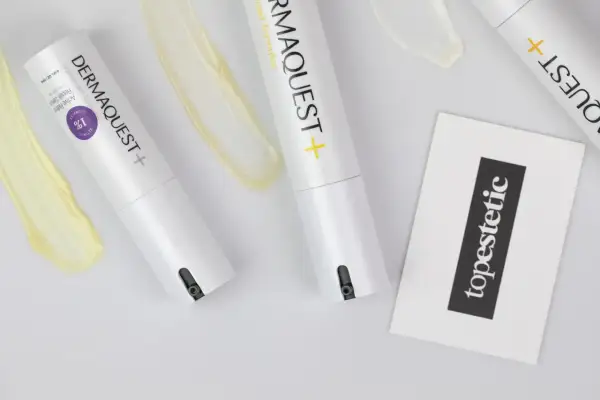 Dwa opakowania serum z retinolem i kwasem hydroksylowym, obok smugi kremu i karty z napisem "topestetic".