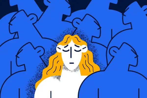 Eine Frau mit blonden Haaren und traurigem Gesichtsausdruck steht inmitten einer blauen Masse von Menschen, die sie zu ignorieren scheinen.